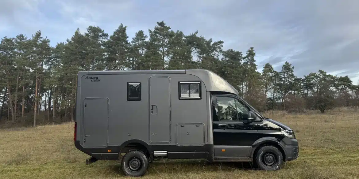 Woelcke Autark Crafter C11 als schwarzer Allrad-Camper auf einer Wiese