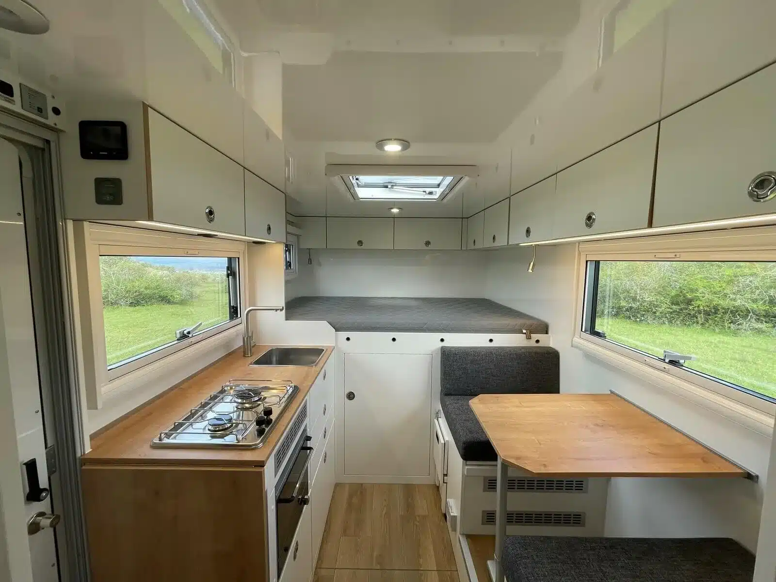 Innenansicht Woelcke Autark Crafter C6 mit Küchenzeile, Sitzgruppe und Bett
