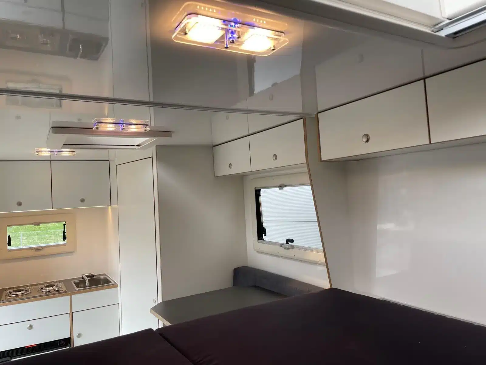 Innenraum des Woelcke Autark Hilux mit Küche, Sitzgruppe, Schränken und umgebautem Bett