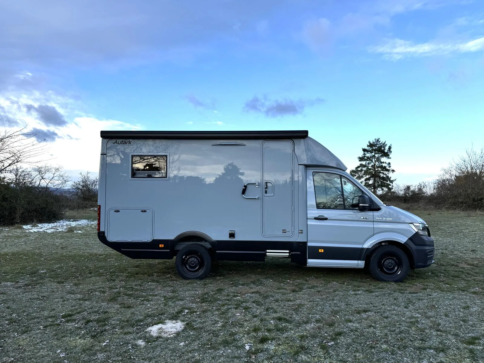 Woelcke Autark MAN TGE C9 Allradwohnmobil seitlich fotografiert auf einer offenen Wiese