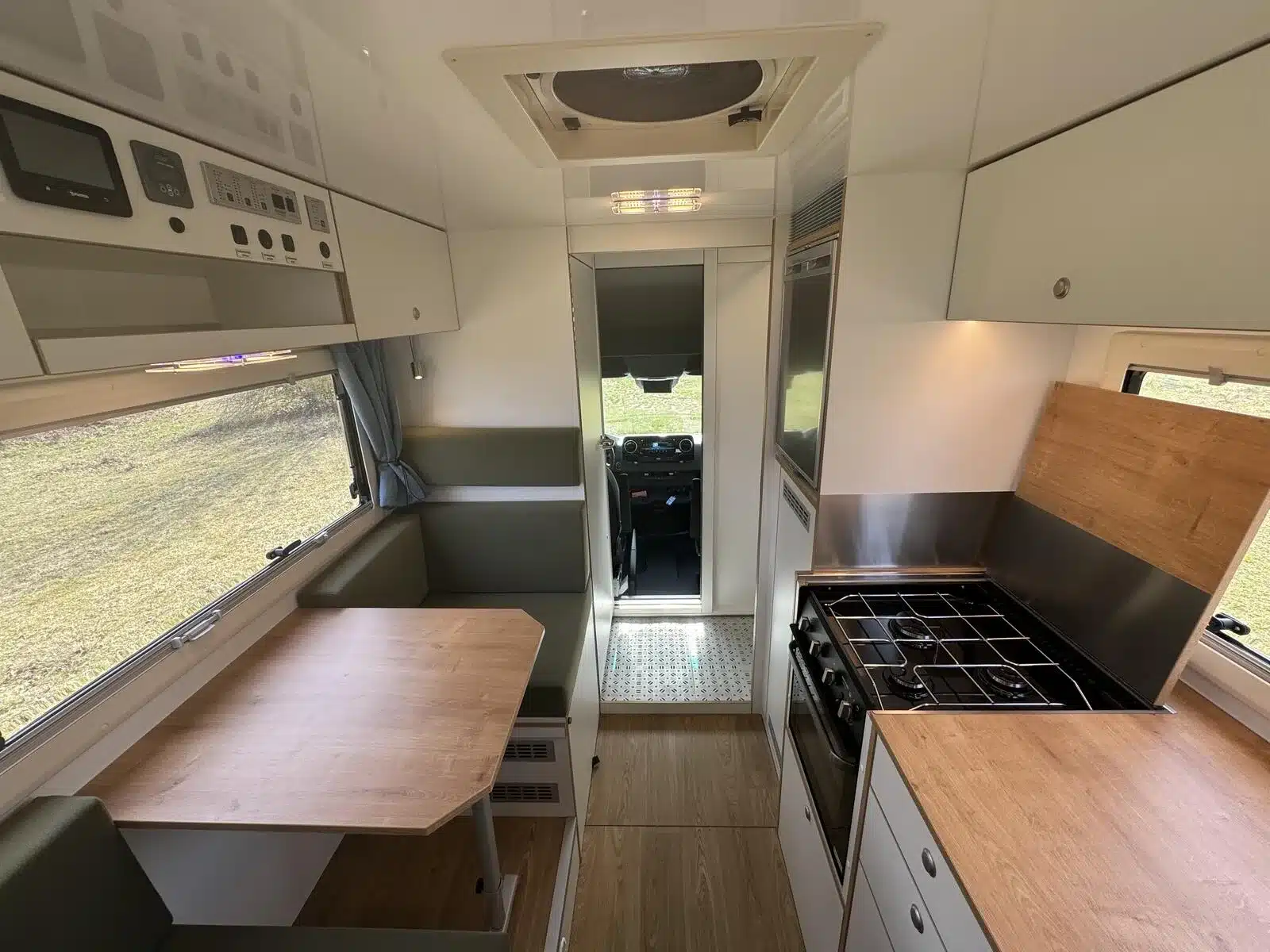 Innenraum eines Woelcke Autark Runner R10-lang mit Sitzgruppe, Küche und Fahrerhaus