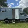 Graues Woelcke Autark runner R4-2024 Wohnmobil mit geöffneter Seitentür auf einer Wiese