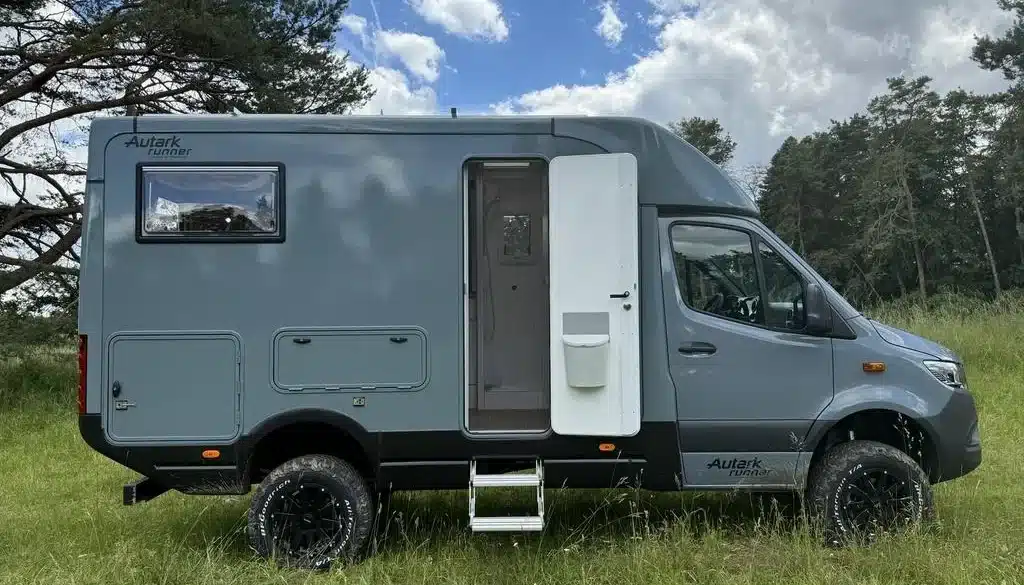 Graues Woelcke Autark runner R4-2024 Wohnmobil mit geöffneter Seitentür auf einer Wiese
