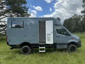 Graues Woelcke Autark runner R4-2024 Wohnmobil mit geöffneter Seitentür auf einer Wiese