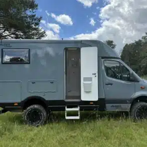 Graues Woelcke Autark runner R4-2024 Wohnmobil mit geöffneter Seitentür auf einer Wiese
