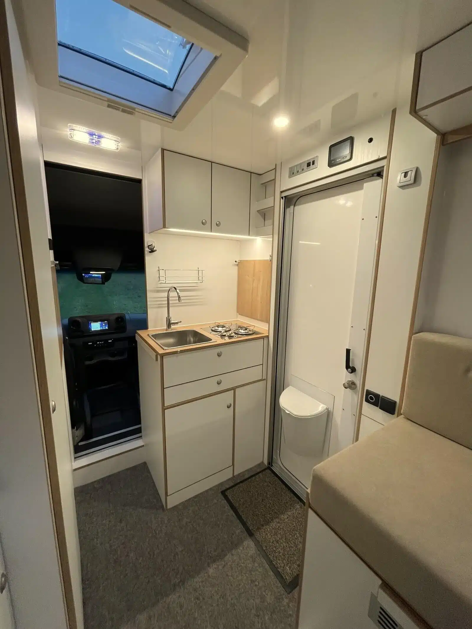 Innenraumansicht eines Woelcke Autark runner R4 mit Küchenzeile, Toilette und Blick ins Fahrerhaus