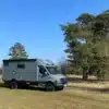 Woelcke Autark runner R6-lang 2023 Allrad-Reisemobil auf einer Wiese vor Bäumen