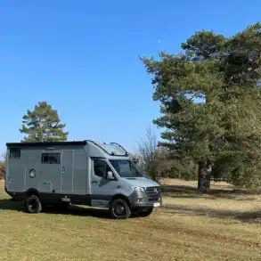 Woelcke Autark runner R6-lang 2023 Allrad-Reisemobil auf einer Wiese vor Bäumen