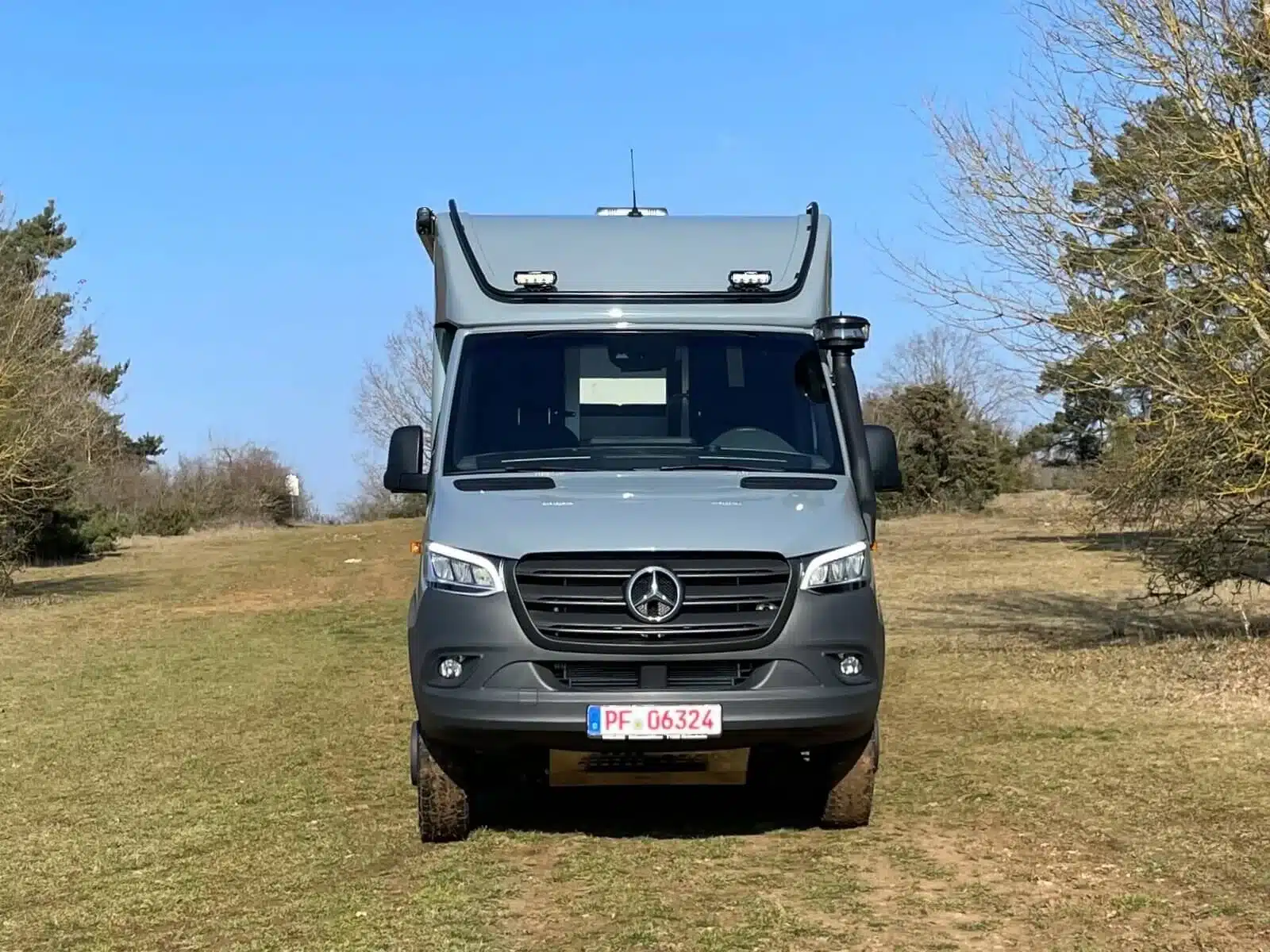Der Woelcke Autark runner R6-lang 2023 als Reisemobil auf einer Wiese, fotografiert von vorn.