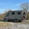 Seitenansicht eines grauen Woelcke Autark runner R7 Allradwohnmobils auf MB Sprinter 419CDI Basis im Gelände.