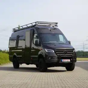 Schwarzer Mercedes-Benz Sprinter 419 4x4 Camper X-PED mit Hochdach und Dachgepäckträger auf einem Parkplatz