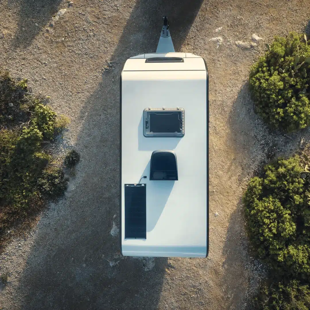 Luftaufnahme eines Wohnmobildachs mit installierter Dometic FreshJet FJZ7 2600 Klimaanlage und Solarpanel auf Kiesplatz