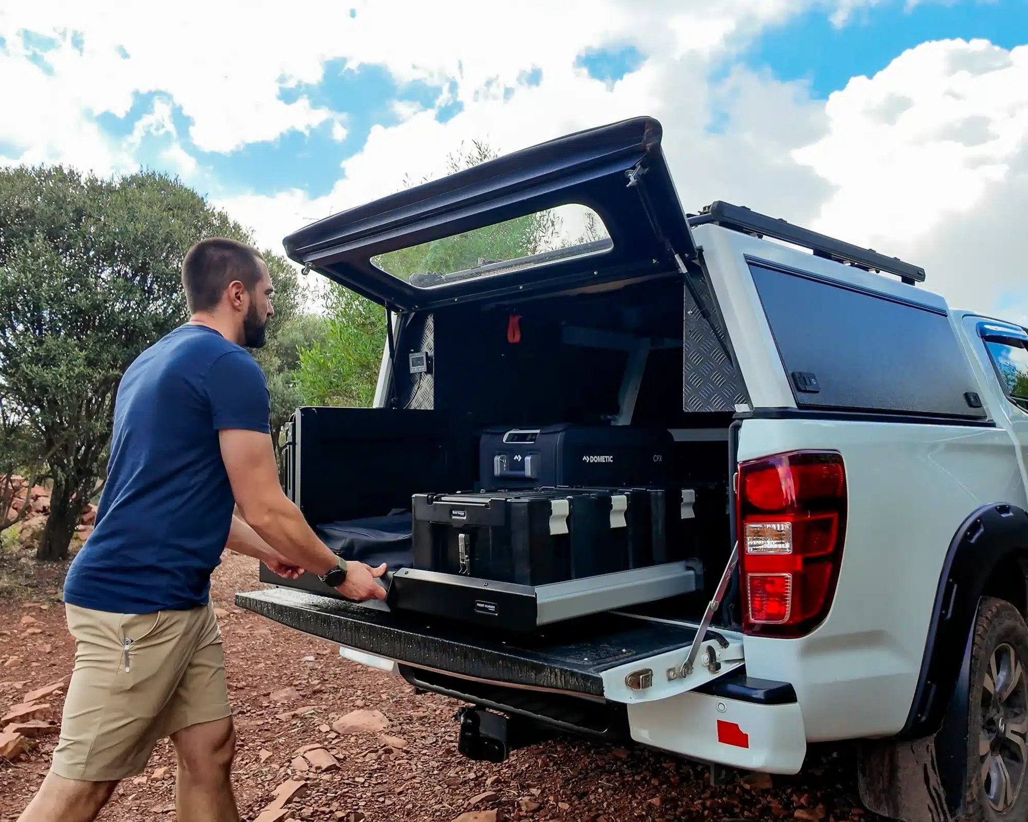 Front Runner Dometic Ladeflächenauszug auf der Ladefläche eines weißen Pick-ups mit ausgezogenem System und Ausrüstung.