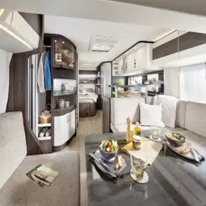 Innenansicht des Hobby PRESTIGE 2027 Wohnwagens mit heller Polsterkombination und moderner Einrichtung.