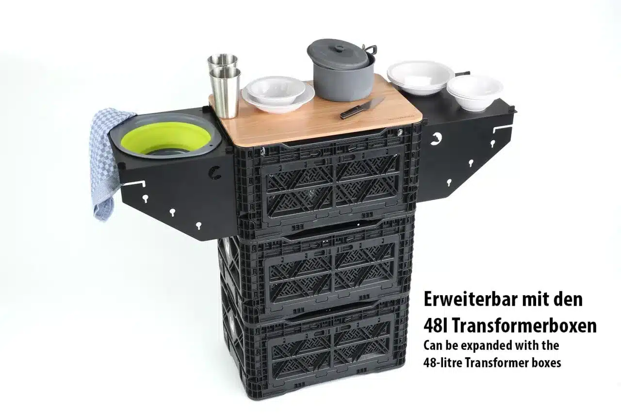 Küchenkiste in 48l Transformer Box – mobile Outdoor-Küche mit seitlichen Ablagen, Geschirr und Kochtopf, aufgebaut für den Campinggebrauch.