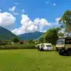 Wohnmobile und Caravan auf einem Stellplatz in Rumänien mit Bergen im Hintergrund