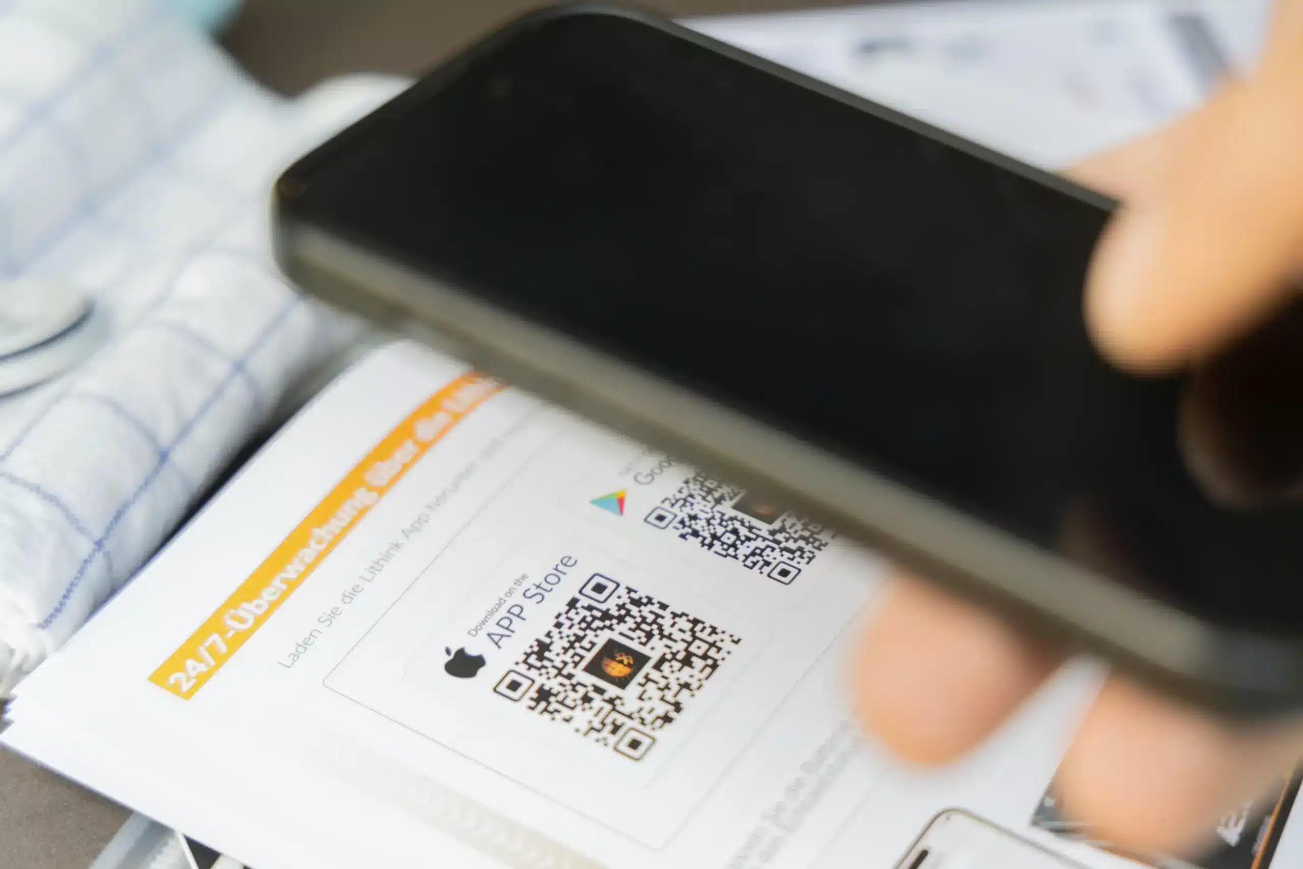 Smartphone scannt QR-Code für Lithink App auf der Bedienungsanleitung eines Akkusystems.