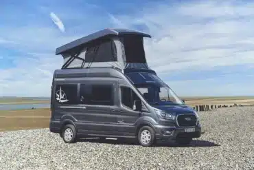 Westfalia Meridian Kastenwagen mit Aufstelldach, geparkt auf einem Kiesstrand mit Blick aufs Meer