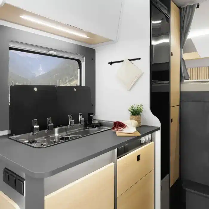 Küchenbereich mit Kochstelle und Kühlschrank im Ahorn Camp A 720 Alkoven-Wohnmobil