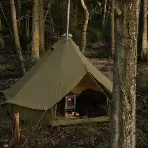 Asgard 7.1 Glamping Zelt in Green Khaki mit geöffnetem Eingang und Holzofen, aufgebaut im Wald