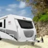 BELA DBS 485 Wohnwagen am Sandstrand mit Palmen im Vordergrund
