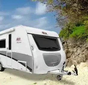 BELA DBS 485 Wohnwagen am Sandstrand mit Palmen im Vordergrund