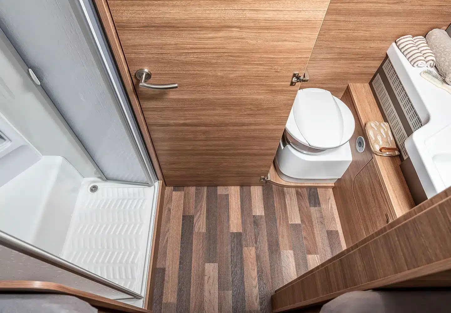 Badezimmer mit Duschkabine, Toilette und Waschbecken im WEINSBERG CaraCore Wohnmobil