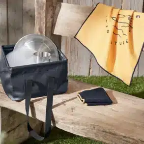 Faltbare Spülschüssel in Dunkelblau, mit Geschirr und Schaum gefüllt, auf einer Holzbank – ideal für Camping und Vanlife