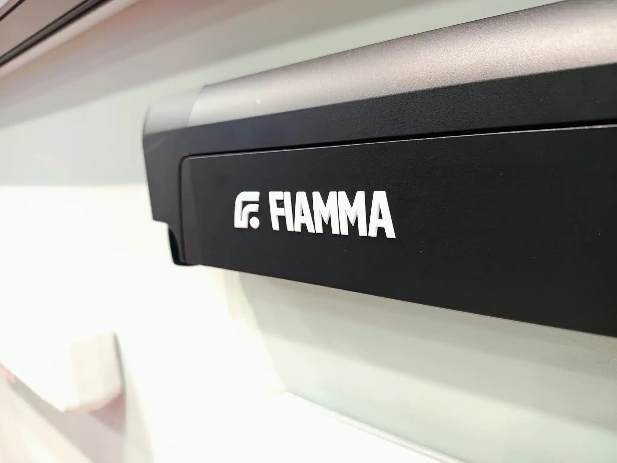 Nahaufnahme eines schwarzen Fiamma-Markisengehäuses an einem Freizeitfahrzeug
