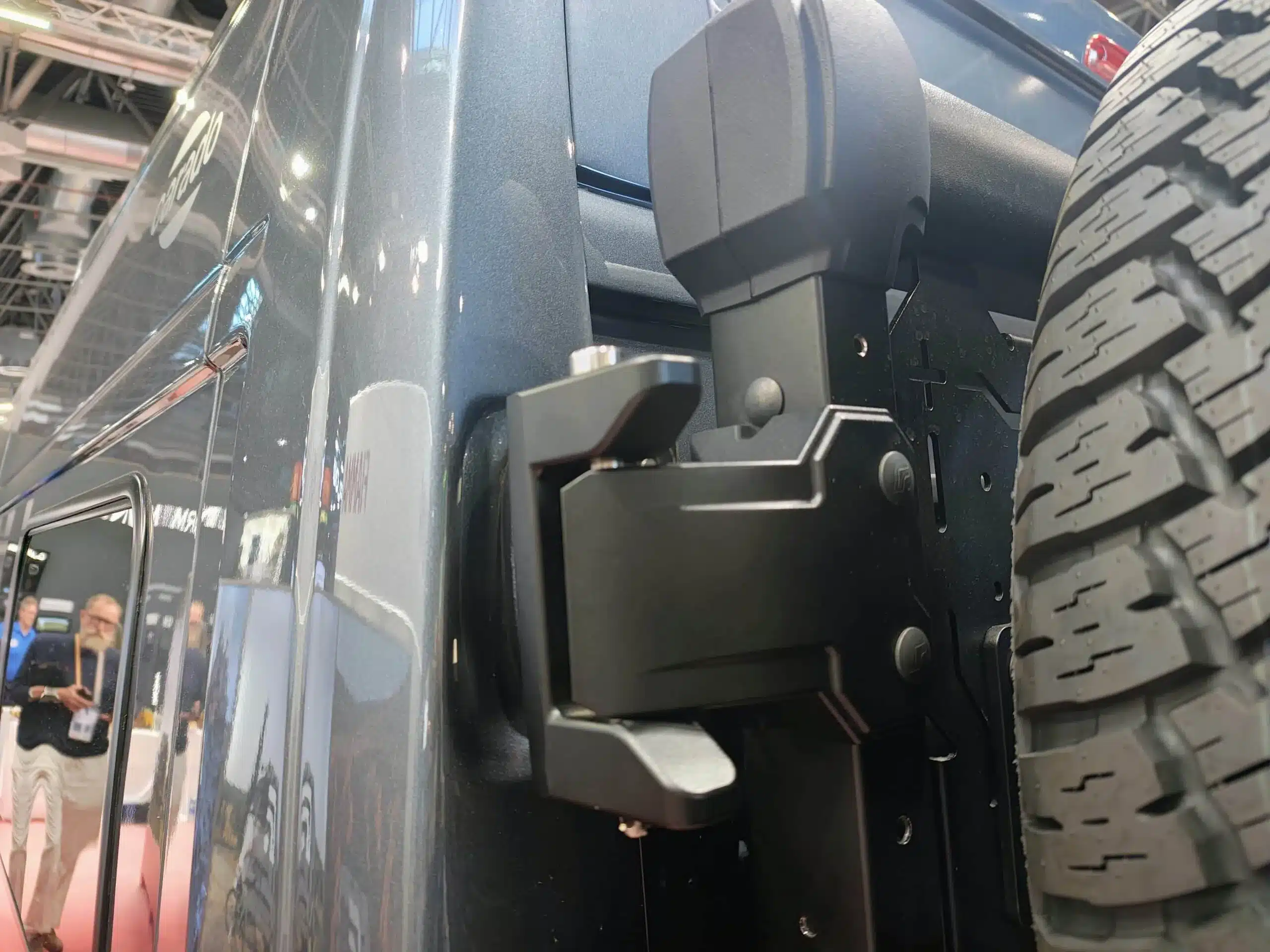 Nahaufnahme eines schwarzen Fiamma Fahrradträgers neben dem Hinterrad eines Campingfahrzeugs