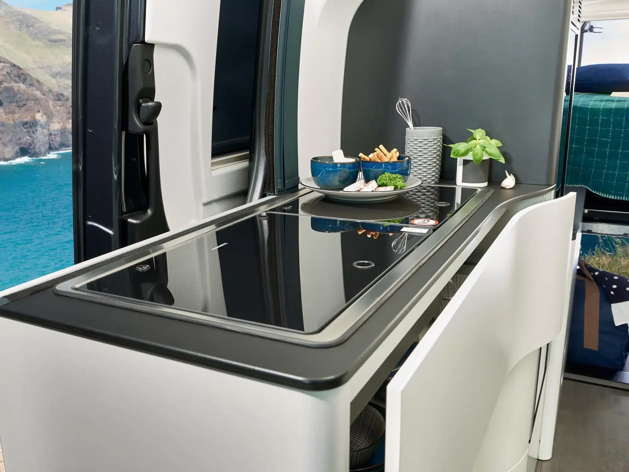 Küchenbereich mit Kochfeld, Spüle und Ablagefläche im Westfalia James Cook 600 E Campervan