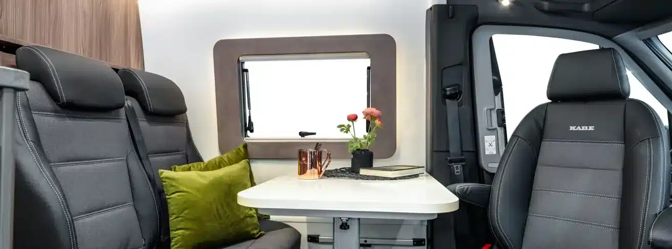 Dinette mit Tisch, Sitzbank und Fahrersitz im KABE Abisko Van 690 LB