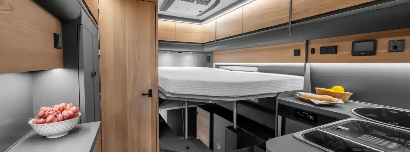 Innenansicht des KABE Affinity One mit höhenverstellbarem Bett und L-Küche