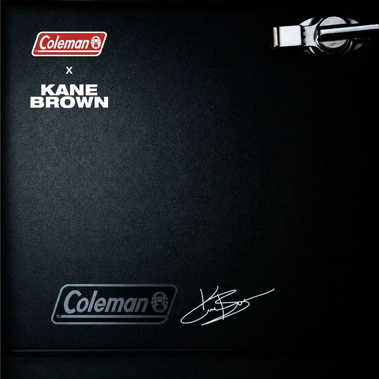Detailansicht des matten Stahldeckels der Kane Brown x Coleman® Reunion 54 Qt. Steel Belted Matte Cooler mit Logos und Signatur.