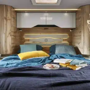 Festes Heckbett mit farbenfroher Bettwäsche, gemütlicher Innenausstattung und viel Stauraum im Le Voyageur LV7.5CF Wohnmobil