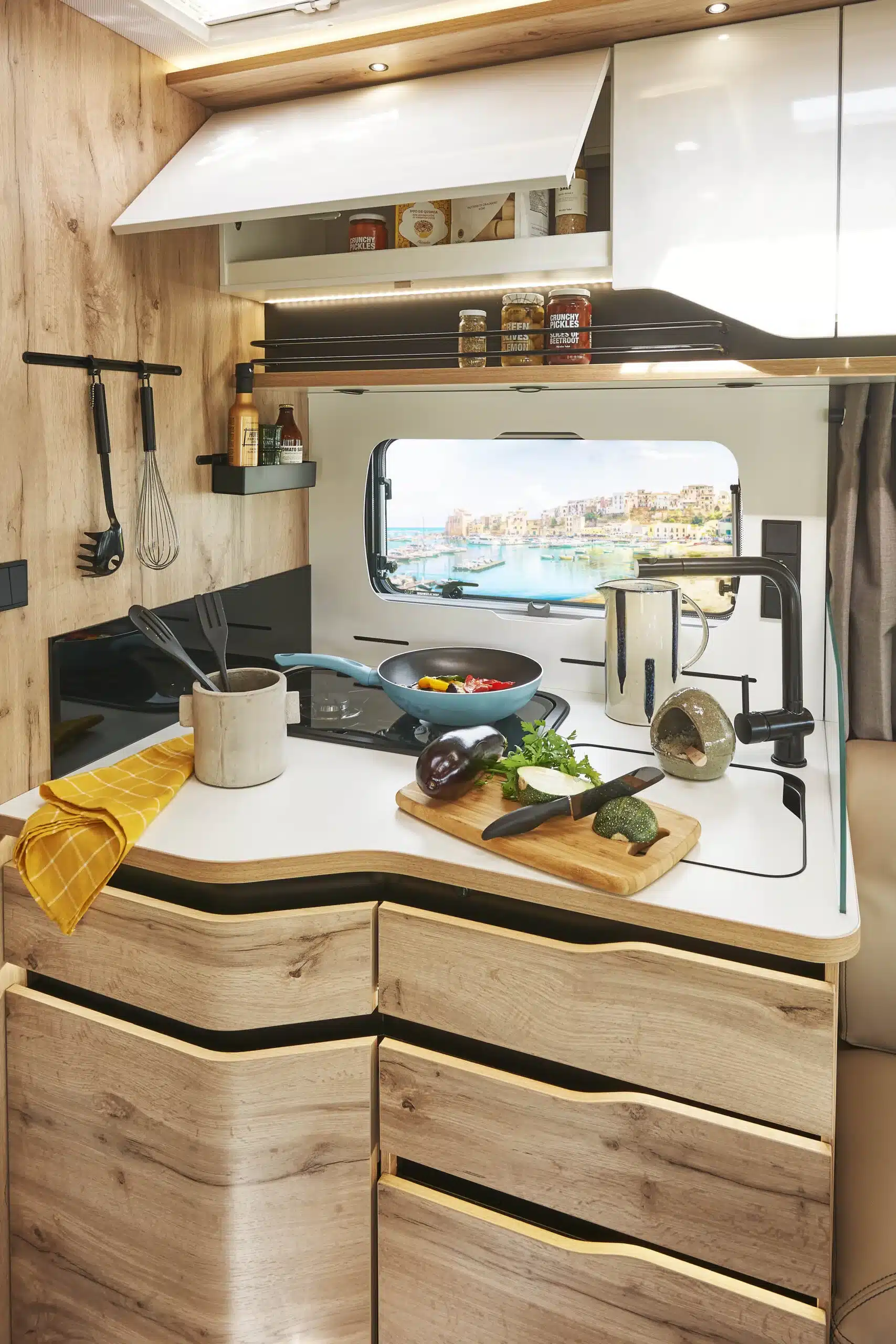 Moderne Küche mit großer Arbeitsfläche im Le Voyageur LV7.5CF Reisemobil, mit Küchenutensilien und frischem Gemüse