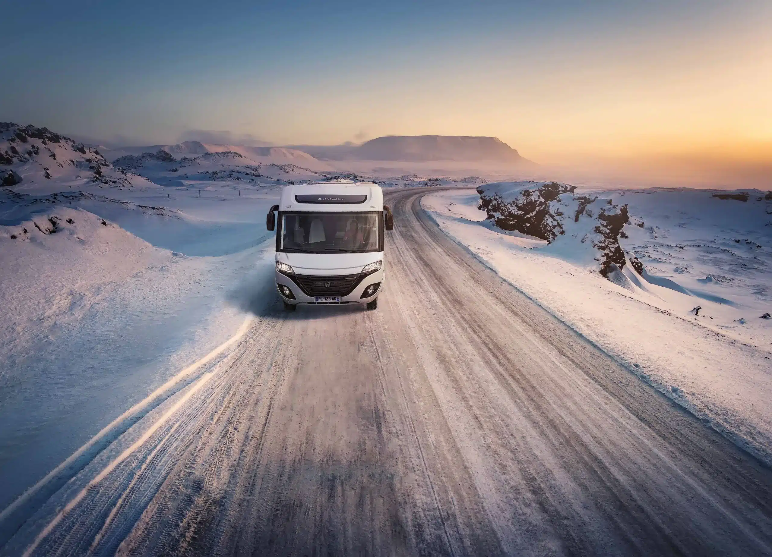 Frontansicht eines LE VOYAGEUR LV8.5CF Reisemobils, das auf einer verschneiten Straße in winterlicher Landschaft fährt.