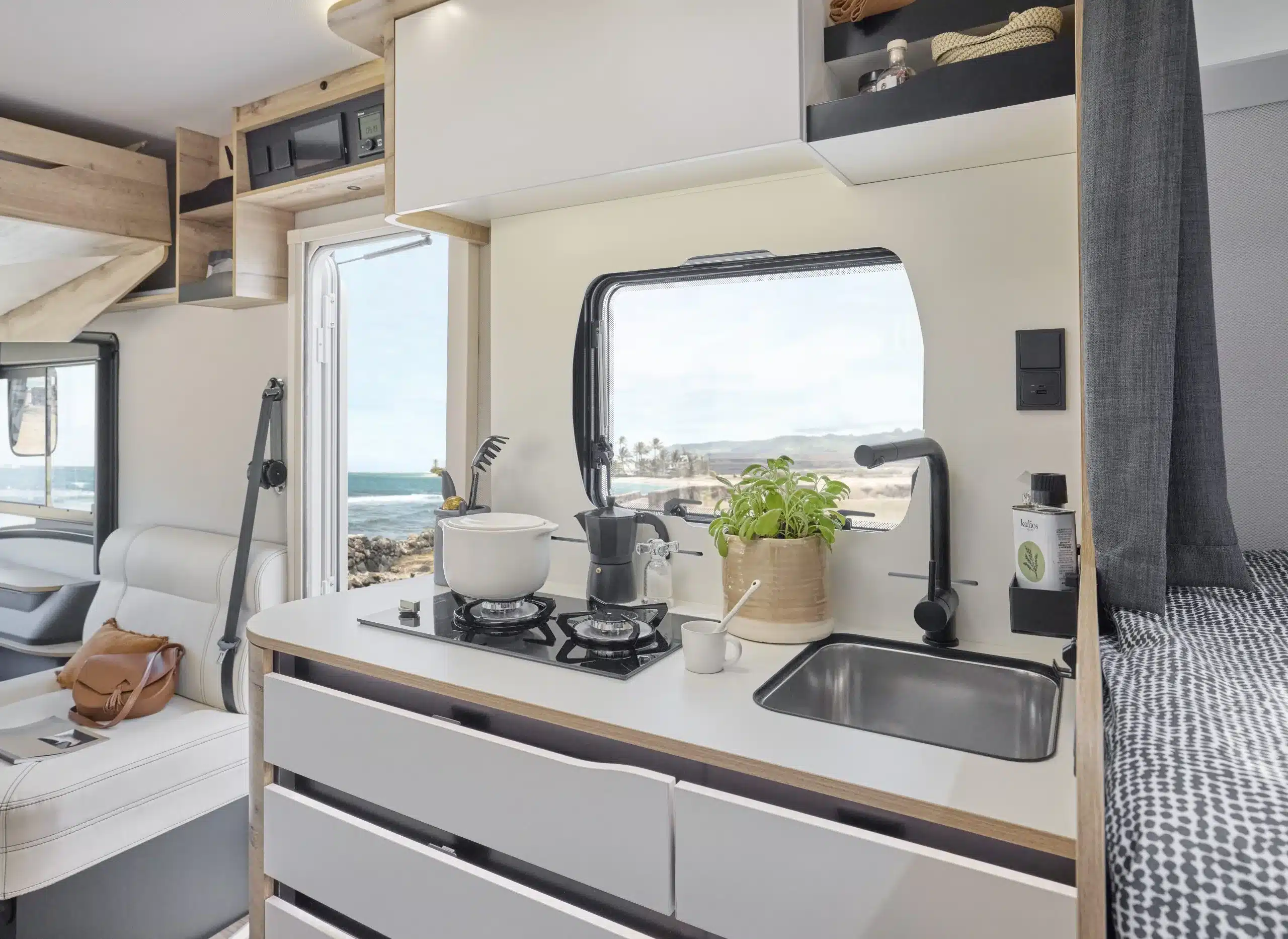 Küche mit Gaskocher, Spüle und Sitzbereich im LE VOYAGEUR LV7.0 GJF Wohnmobil.