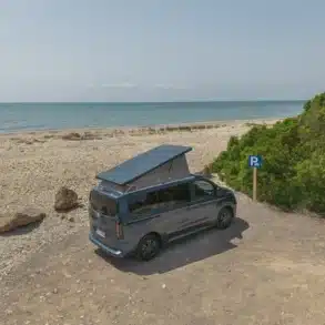 Panama Peak (5,05m) Campervan parkt mit geöffnetem Aufstelldach an einem Strand