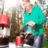 Frau bereitet mit dem Coleman QuikPot™ Propane Coffeemaker frischen Kaffee im Freien beim Camping zu