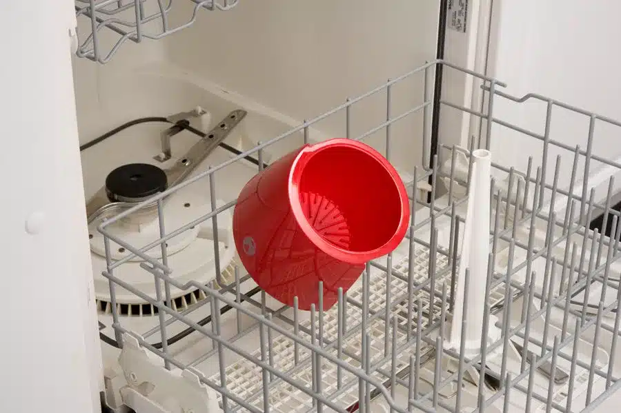Roter Kunststoff-Filterkorb aus dem Coleman QuikPot Propane Coffeemaker in einer Spülmaschine zur Reinigung