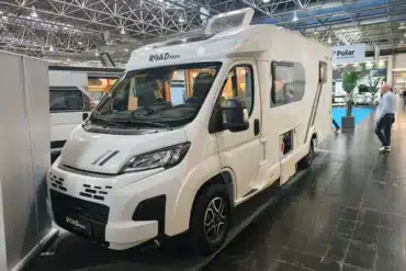 Weißes ROADfans-Reisemobil mit geöffneter Seitentür auf einem Messestand