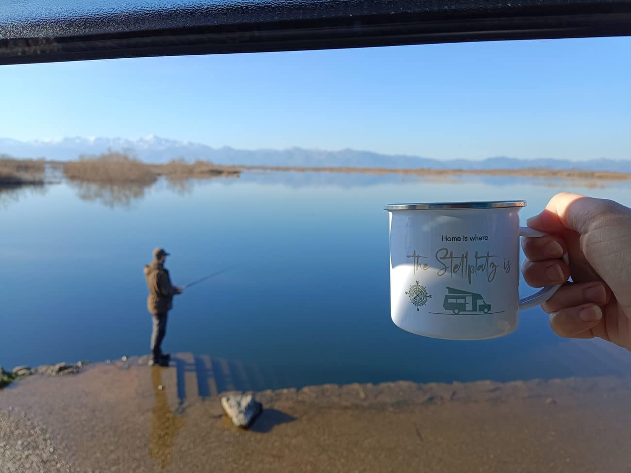 Campingtasse mit Blick auf einen Stellplatz am Wasser in Montenegro