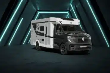 Ahorn Camp T 690 Eclipse Edition – Teilintegriertes Reisemobil in schwarz-weißer Lackierung vor beleuchtetem Hintergrund