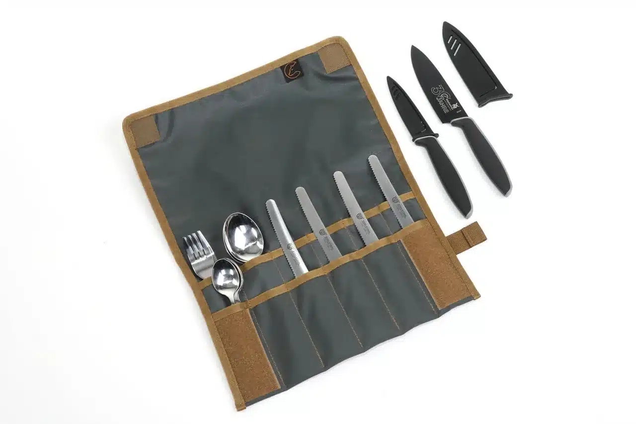 Campingbesteck und Küchenmesser in geöffneter Tool Roll Hungry Edition mit Nylonhülle, daneben zwei WMF-Messer mit Klingenschutz.