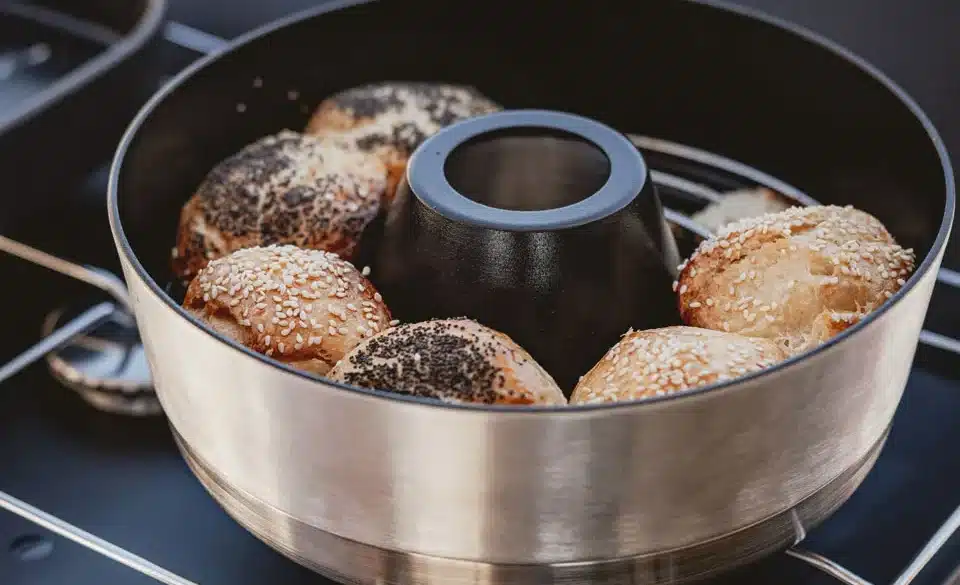 Mobiler Backofen VAMO® mit frisch gebackenen Brötchen auf einem Campingkocher.