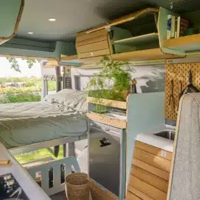 Innenansicht des VAN-Jorn Adventure Campers mit Bett, Stauraum, Küchenzeile und natürlichen Materialien