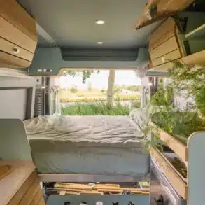 Innenansicht eines elektrischen VAN-Jorn CHARGE Campers mit Bett, Stauraum und modularer Küche