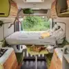 Moderner, modular ausgebauter Innenraum eines VAN-Jorn CUSTOM Campervans mit Sitzgelegenheit, Küche und Bett