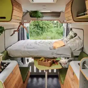 Moderner, modular ausgebauter Innenraum eines VAN-Jorn CUSTOM Campervans mit Sitzgelegenheit, Küche und Bett
